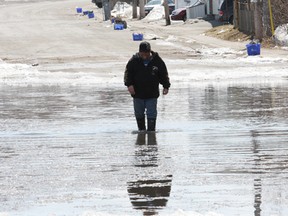 JOHN LAPPA/THE SUDBURY STAR       
George Young trudges through ice and water covering Percy Avenue in the Flour Mill in Sudbury on Wednesday, April 16. Perreault Street is also partially covered, prompting homeowners to place sandbags in their front yards.