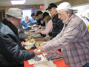 John Konecny, right, was among the volunteers who helped out at the free turkey lunch held at Campbell A.M.E. Church on April 16.