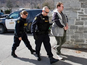 James Beau Jeffery, 29, who was charged with second-degree murder in relation to the death of his mother in 2011, is escorted into the Picton courthouse by OPP officers. — JEROME LESSARD/THE INTELLIGENCER/QMI AGENCY