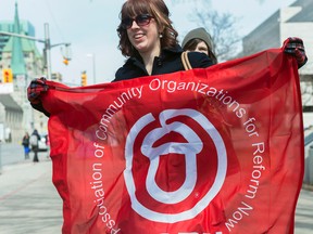 Natalie Lalonde holds up the ACORN flag before the group protested for cheaper internet on Thursday morning. The protest began at 11:00 at the Human Rights Building. Sarah Taylor/Ottawa Sun/QMI Agency