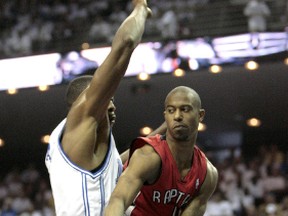 Toronto Raptors guard T.J. Ford passes  while being guarded by Orlando Magic Dwight Howard during Game #1 during the first round of the 2008 NBA playoffs. (Ernest Doroszuk, Toronto Sun)