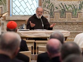 Pope Francis (R, back to camera) listens to Father Raniero Cantalamessa (C) during a Lent sermon at the Vatican April 11, 2014. REUTERS/Osservatore Romano