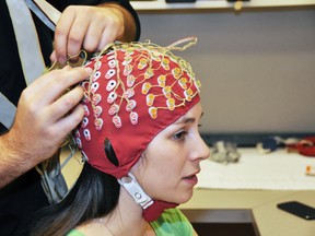 Ashley Livingstone, an SFU first year master's student, models a cap that is fitted with 128 electrodes. They are hooked up to monitor the wearer's brain activity. (Simon Fraser University/ Handout)