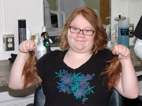 Morgan Hall, a Grade 9 student at Arthur Voaden Secondary School, shows the locks of hair she donated Thursday for wigs for cancer patients.