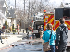 A West Hill townhouse, off Morrish Rd., was gutted by a fire that began in the garage Saturday. Shocked residents look on as Toronto firefighters, battle the blaze. The back of pumper 215 can be seen on the extreme right of the photo. (Chris Doucette/Toronto Sun)