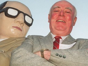 Alistair MacLeod poses with a statue outside the NAC in Ottawa in this file photo taken in 2000. (Tony Caldwel/ QMI Agency file photo)