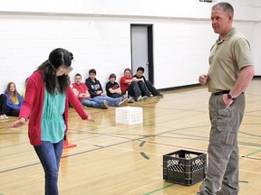 Andrea Aquino tries to walk a straight line, one foot in front of the other wearing the Fatal Vision Goggles, while Kevin Brandvold, who runs the Safe Roads program, looks on. The school recently held a drug and alcohol awareness day. 
Submitted photo