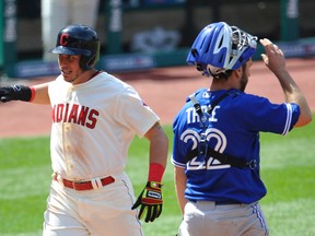 Cleveland Indians shortstop Asdrubal Cabrera (left) celebrates as he scores beside Toronto Blue Jays catcher Josh Thole (22) in the sixth inning at Progressive Field on Sunday. (David Richard-USA TODAY Sports)