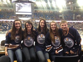 Kenadi (far left) and Monica (centre) won the Homes by Avi and Edmonton Sun photo contest and were treated to an Oilers game.