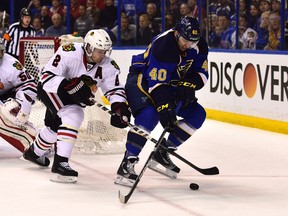 Chicago Blackhawks defenseman Duncan Keith (2) and St. Louis Blues center Maxim Lapierre (40) battle for the puck in game one during the first round of the 2014 Stanley Cup Playoffs at the Scottrade Center on Apr 17, 2014 in St. Louis, MO, USA. (Scott Rovak/USA TODAY Sports)