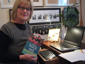 Author Liz Parsons shows off her book "Raising Huck and Ted" in her Sarnia, Ont. office Thursday, April 17, 2014. The mother of two and former elementary teacher shares a treasure trove of family stories and parenting advice in her first book. BARBARA SIMPSON/THE OBSERVER/QMI AGENCY
