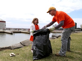 Ailsa Kerr, 7, works with her dad Dave Kerr as they were part of a small group of people who helped clean up the shoreline of Confederation Park on Monday.  
IAN MACALPINE/KINGSTON WHIG-STANDARD/QMI AGENCY