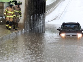 FILE: Firefighters check out an SUV stuck in the flooded railway underpass on 127 Street north of Yellowhead Trail, following heavy rains in Edmonton, Alta., Tuesday June 25, 2013. David Bloom/Edmonton Sun