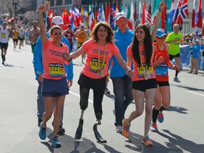 2013 Boston Marathon survivors Celeste Corcoran (C) and her daughter Sydney (R) finish the race with Celeste's sister Carmen Acabbo, who ran the 118th Boston Marathon, in Boston Monday, April 21, 2014. (REUTERS/Brian Snyder)