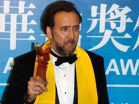 U.S. actor Nicolas Cage poses with his Best Global Actor in Motion Picture award at the Huading Awards ceremony in Macau October 7, 2013. 

REUTERS/Tyrone Siu