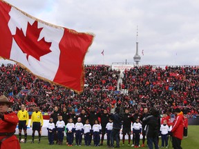 The Toronto FC starters stand for the national anthems before their home game against DC United at BMO Field on March 22, 2014. (JACK BOLAND/Toronto Sun)