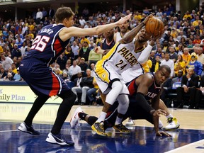 Indiana Pacers forward Paul George takes a shot against Atlanta Hawks forward Kyle Korver (left) and guard Shelvin Mack  in Game 2 of their Eastern Conference quarterfinal series at Bankers Life Fieldhouse in Indianapolis, April 22, 2014. (BRIAN SPURLOCK/USA Today)