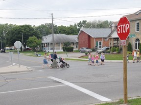 Community members walk along South Edgeware Rd. at Balaclava St. in St. Thomas. File photo