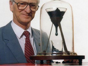 A photo of the late John Mainstone with the pitch drop experiment at the University of Queensland in Australia. Mainstone died in August before he could see the ninth blob of pitch touch down in the beaker. He had missed all three drops during his custodianship. (Photo: Facebook/QMI Agency)