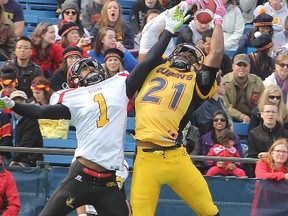 Andrew Lue of Queen's leaps to make the interception against Guelph's A'Dre Fraser during an OUA football game at Richardson Stadium on Oct. 19, 2013. (Michael Lea/The Whig-Standard)