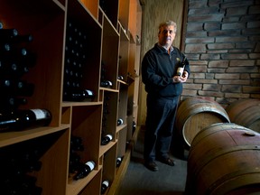Roberto Quai holds a bottle of his merlot wine in the cellar of Quai du Vin, his winery near Sparta, Ontario on Wednesday. Thanks to regulatory changes, Quai's wine will be available at local farmer's markets in London.

CRAIG GLOVER/QMI Agency