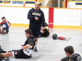 Wallaceburg Red Devils coach Jamie Knight smiles as his team does stretching drills, during a practice held on April 15. The Red Devils open their regular season on the road in Point Edward on April 27.