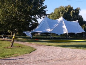A tent that was being set up for a family wedding at 8990 LaSalle Rd. in Brooke-Alvinston stands partially collapsed after a tent pole struck an overhead power line on Aug. 1, 2013. PAUL OWEN/ THE OBSERVER/ QMI AGENCY