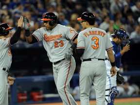 Baltimore Orioles designated hitter Nelson Cruz (23) is greeted at home plate by Orioles left fielder Ryan Lough (9) and third baseman Ryan Flaherty (3) after hitting a grand slam home run against Toronto Blue Jays at Rogers Centre Wednesday night. (Dan Hamilton-USA TODAY Sports)