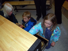 Wendy Gunn, left, explores an artifact with grandson Charlie, 3, and granddaughter Clara, 6, on Wednesday at Jaffa Environmental Education Centre south of Aylmer. The artifact is part of an interactive exhibit that educates students about the Carolinian Life Zone. Ben Forrest/Times-Journal