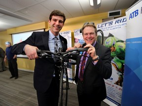 Mayor Don Iveson checks out a bike with ATB President Dave Mowatt during an announcement of the return of the Tour of Alberta on Wednesday. (PERRY MAH/EDMONTON SUN)