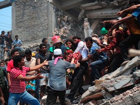 (FILES) This file photo taken on April 24, 2013, shows Bangladeshi volunteers evacuating an injured garment worker after an eight-storey building collapsed in Savar, on the outskirts of Dhaka.  AFP PHOTO / FILES / Munir uz ZAMAN