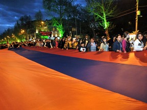 Armenians carry the national flag in Yerevan on Wednesday to commemorate the 99th anniversary of the Ottoman Turkish massacre of Armenians. (AFP/Getty)