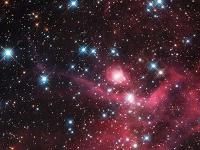 A small part of the Large Magellanic Cloud, one of the closest galaxies to our own, is seen in an undated image taken from NASA's Hubble telescope released Feb. 28, 2014. The collection of small baby stars, most weighing less than the sun, form a young stellar cluster known as LH63. The burning red intensity of the nebulae at the bottom of the picture illuminates wisps of gas and dark dust, each spanning many light-years.   REUTERS/NASA/ESA/Handout via Reuters