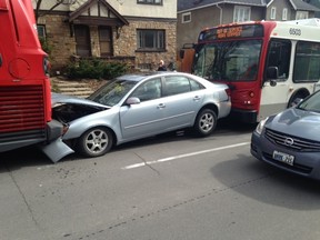 A bus driver is charged with careless driving after his bus slammed into a car on Carling Ave. near Cambridge St. Wednesday, sandwiching the car between two buses. Police say the woman auto driver wasn’t hurt. (DAN POWELL photo submitted to Ottawa Sun)