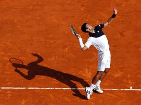 Novak Djokovic of Serbia serves to Roger Federer of Switzerland during their semi-final match at the Monte Carlo Masters in Monaco April 19, 2014. (REUTERS/Eric Gaillard)