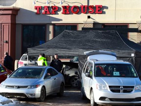 Police investigates a homicide scene outside Hudsons Tap House on 104 ave and 112 st in Edmonton, AB., on Tuesday, Jan 21, 2014.  Ones person died at the scene and another was taken to hospital with a gunshot wound.  Perry Mah/Edmonton Sun