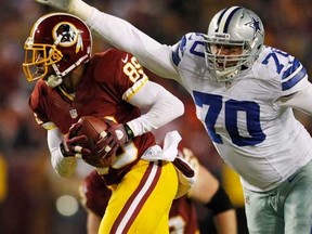 Washington Redskins receiver Santana Moss escapes the arms of Dallas Cowboys defensive tackle Tyrone Crawford in the second half of their NFL football game December 30, 2012. (REUTERS/Gary Cameron)