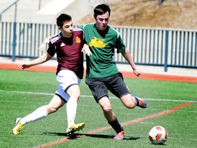 Adrian Soyic of Regiopolis-Notre Dame crashes into Connor Millard of Loyalist during a senior boys soccer game at Tindall Field on Thursday. Regi won 4-0. (Justin Greaves\For The Whig-Standard)
