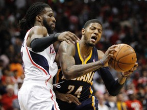 Indiana Pacers forward Paul George is defended by Atlanta Hawks forward DeMarre Carroll during Game 3 of their Eastern Conference quarterfinal series at Philips Arena in Atlanta, April 24, 2014. (BRETT DAVIS/USA Today)