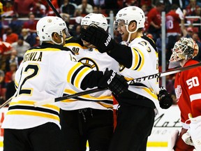 Boston Bruins right wing Jarome Iginla (left) is congratulated by teammates after scoring the game-winning overtime goal against the Detroit Red Wings in Game 4 of their Eastern Conference quarterfinal series at Joe Louis Arena in Detroit, April 24, 2014. (RICK OSENTOSKI/USA Today)
