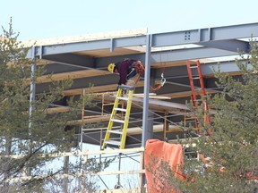 Gino Donato/The Sudbury Star
City council will be debating development charges it should apply against new developments. In this file photo, a worker puts up boards the the new J.L. Richards building on Countryside Drive earlier this year. J.L. Richards & Associates Limited is a multidisciplinary A&E practice offering services in architecture, all core engineering disciplines and planning.The building should be open in the fall.