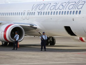 Indonesian air force soldiers hold rifles they guard near a Virgin Australia airplane at Denpasar airport in the resort island of Bali April 25, 2014. The pilot of a Virgin Australia plane flying from Brisbane to Bali on Friday reported a hijacking attempt. REUTERS/Stringer