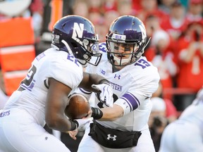 Quarterback Trevor Siemian of the Northwestern Wildcats hands the ball to running back Treyvon Green during their game against the Nebraska Cornhuskers at Memorial Stadium on November 2, 2013. (Eric Francis/Getty Images/AFP)