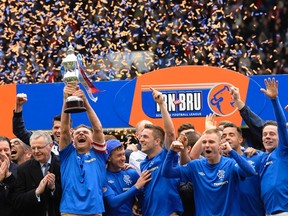 Glasgow Rangers captain Lee McCulloch lifts the league trophy after beating Berwick Rangers in their Scottish Third Division match at Ibrox Stadium in Glasgow May 4, 2013. (REUTERS/Russell Cheyne)