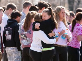 Students mourn in front of Jonathan Law High School in Milford, Conn., April 25, 2014. Maren Sanchez, 16, was killed on Friday in an attack inside a Connecticut high school and authorities were investigating reports she was stabbed by a fellow student after rejecting his invitation to the prom, police said. REUTERS/Michelle McLoughlin