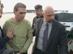 This file photograph courtesy of the Service de Police de la Ville de Montreal (SPVM) shows Luka Rocco Magnotta (C) escorted by police upon arrival from Germany.

AFP PHOTO / Service de Police de la Ville de Montreal