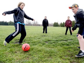 Connor Ellis.11, left, lines up the ball against keeper Edwin Avery, 12, while Nathan Ellis, 13, and Tyler Ellis, 11, wait to pick up the rebound during an impromptu game of soccer at the Lambton Kent Composite School in Dresden, On., Friday April 25, 2014. North Kent Coun. Joe Faas is bringing a proposal to upgrade the soccer grounds to council Monday. Diana Martin/Chatham Daily News/QMI Agency