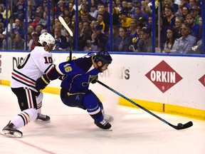 St. Louis Blues defenceman Roman Polak (46) controls the puck as Chicago Blackhawks forward Patrick Sharp pressures him during Game 5 of their first-round NHL playoff series at Scottrade Center. (Scott Rovak/USA TODAY Sports)
