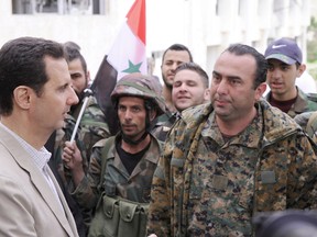 Syrian President Bashar al-Assad, left, talks to soldiers during his visit to Maaloula, northeast of Damascus on April 20,  in this photo released by Syria’s national news agency SANA. 
HANDOUT VIA REUTERS
