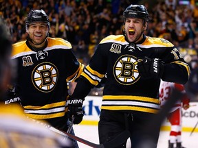 Milan Lucic of the Boston Bruins celebrates his goal past Jonas Gustavsson of the Detroit Red Wings with teammate Jarome Iginla in the third period in Game 5 at TD Garden on April 26, 2014. (Jared Wickerham/Getty Images/AFP)